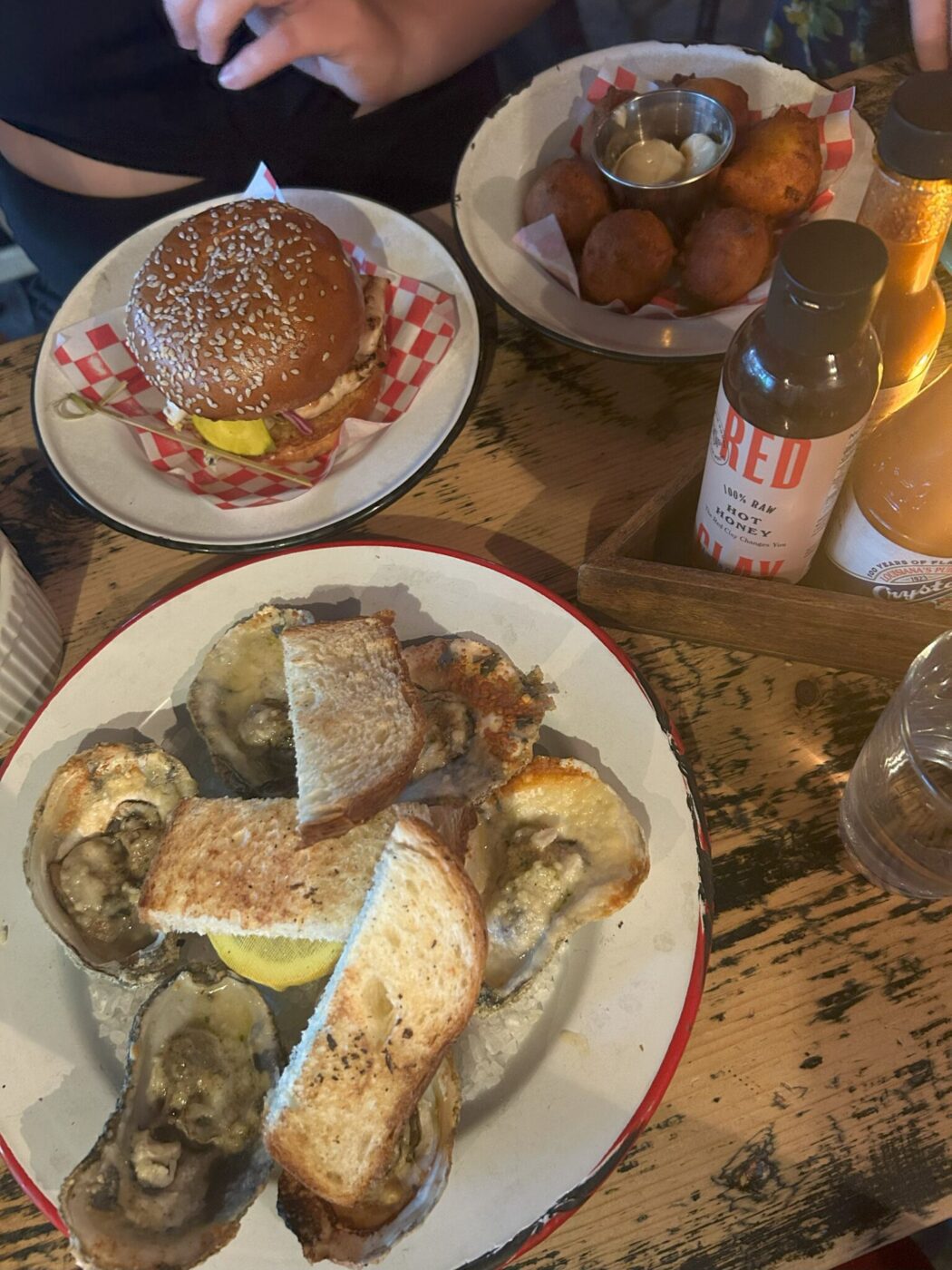 Char-grilled oysters, grilled chicken sandwich, and hushpuppies at Leon's Oyster Shop in Charleston, South Carolina